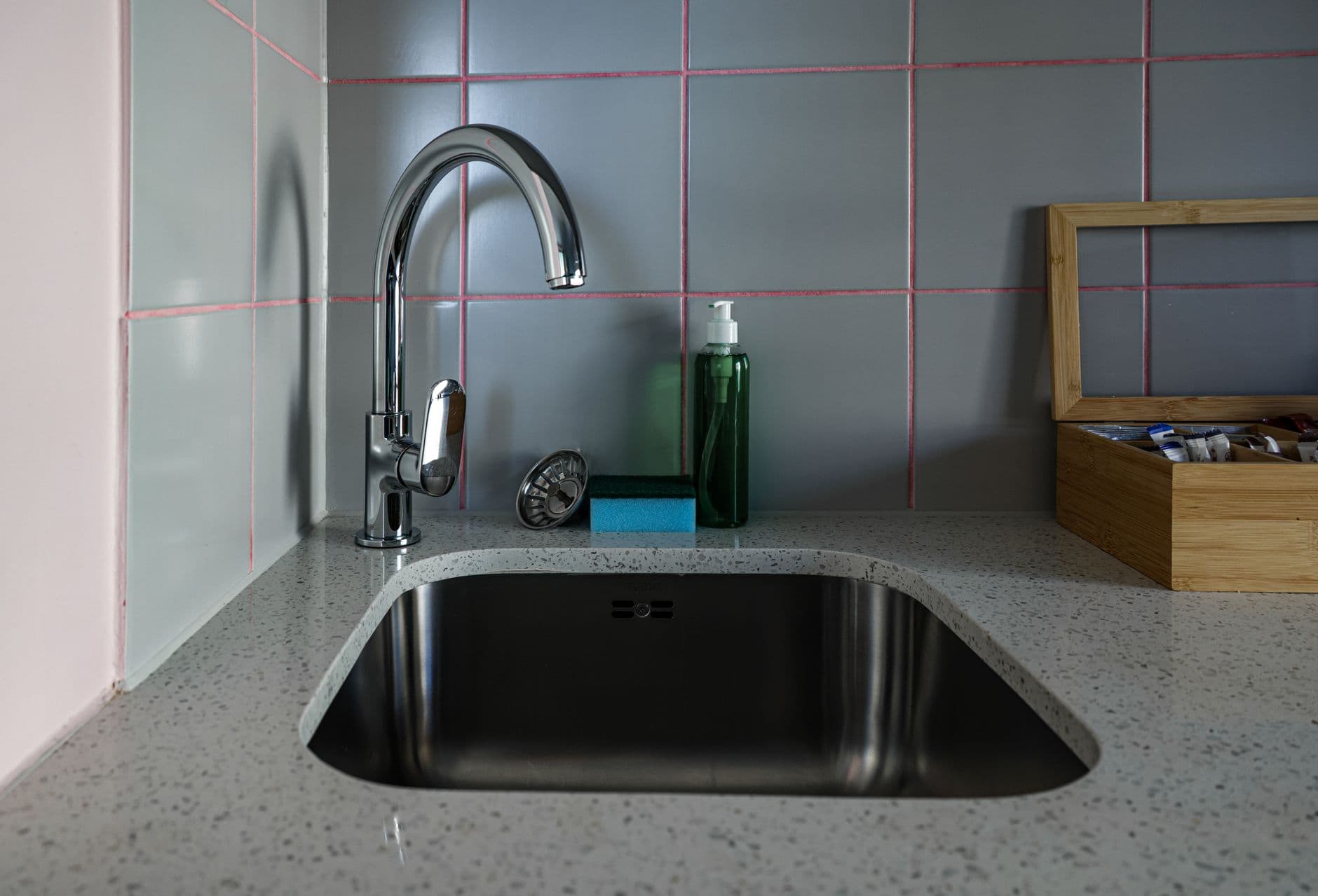 Kitchen sink with a chrome faucet and accessories on the countertop