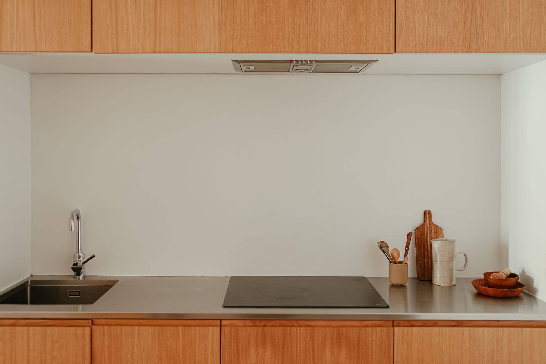 Minimalist kitchen with wooden cabinets and stainless steel surfaces