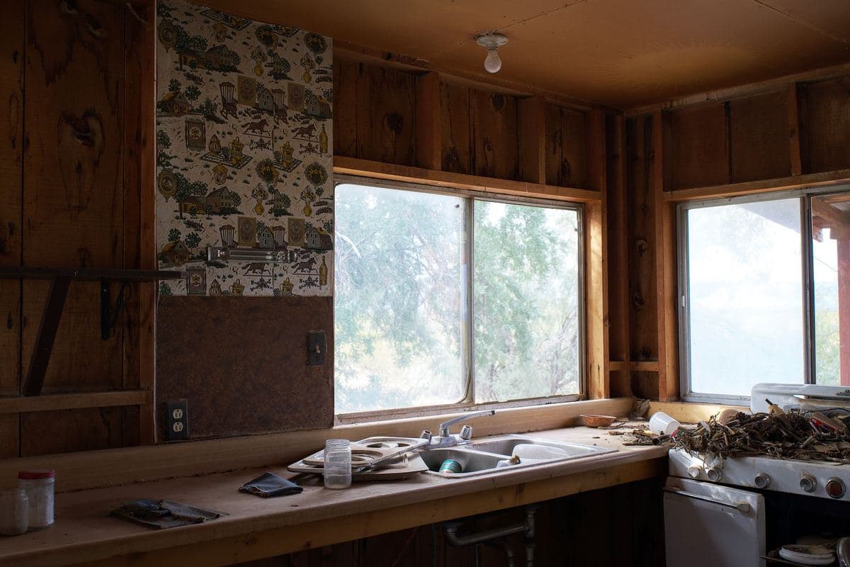 Worn kitchen interior with dated fittings and an old sink