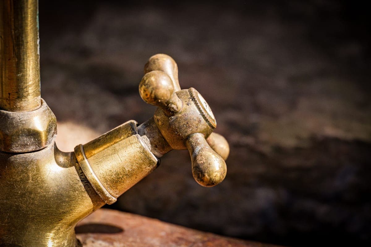 Two-handle bridge kitchen faucet in a warm metallic finish