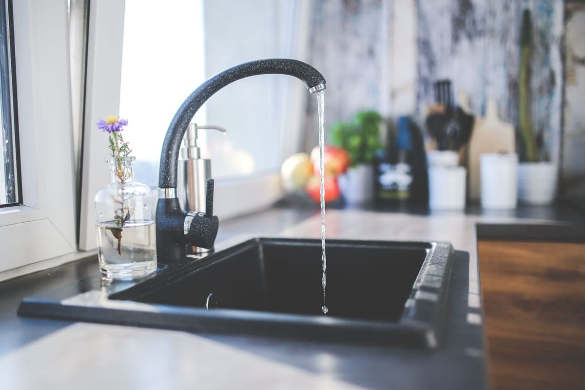 Glass of clear water being filled at a kitchen tap