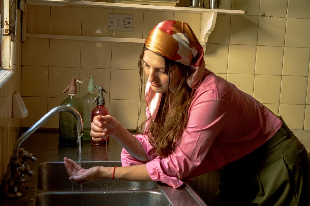 Pull-down faucet spray head rinsing a colander in a kitchen sink