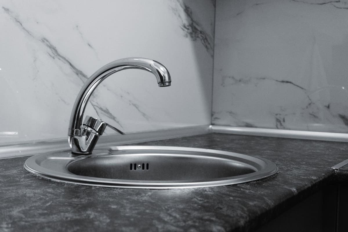 Compact kitchen sink and faucet under a window in a small kitchen