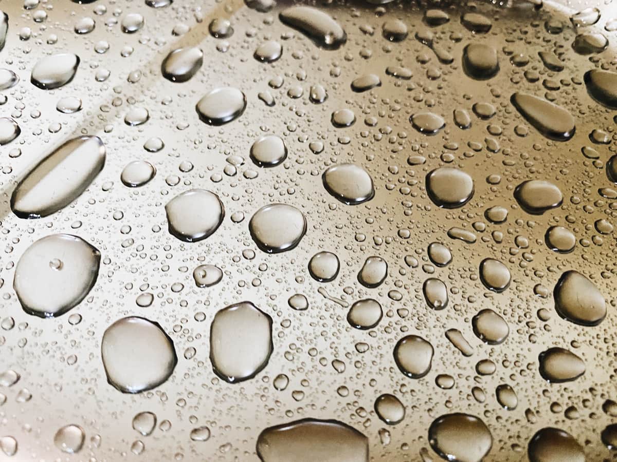 Water droplets beading and drying on a metal surface