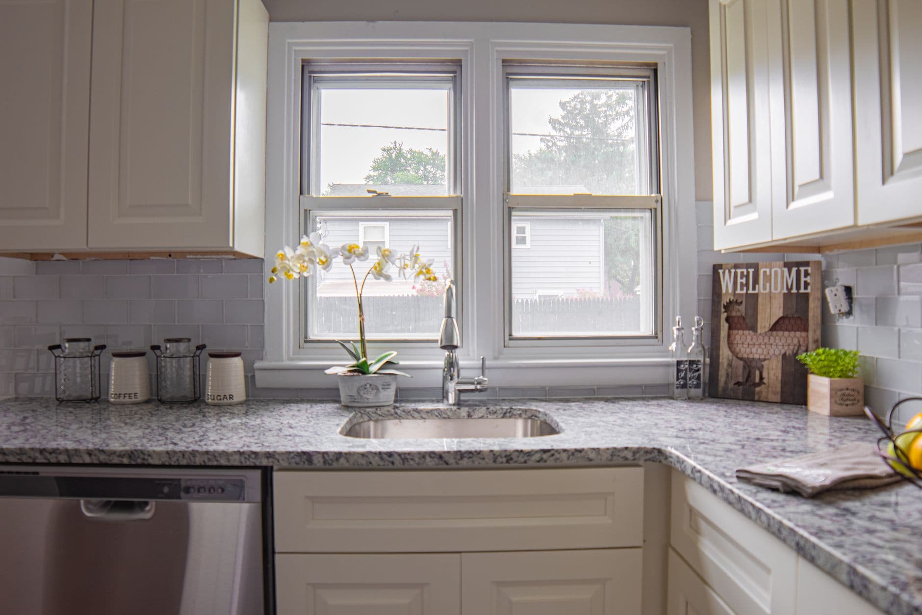 Modern kitchen with a large sink set into a stone countertop below a window