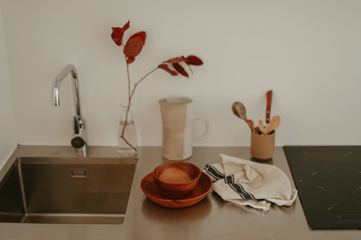 Cloth wiping down a stainless steel kitchen sink basin