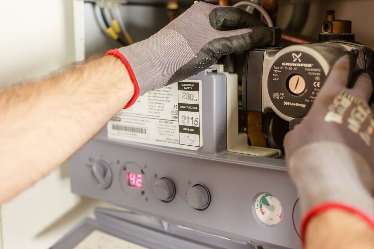 Plumber working on pipework under a kitchen sink