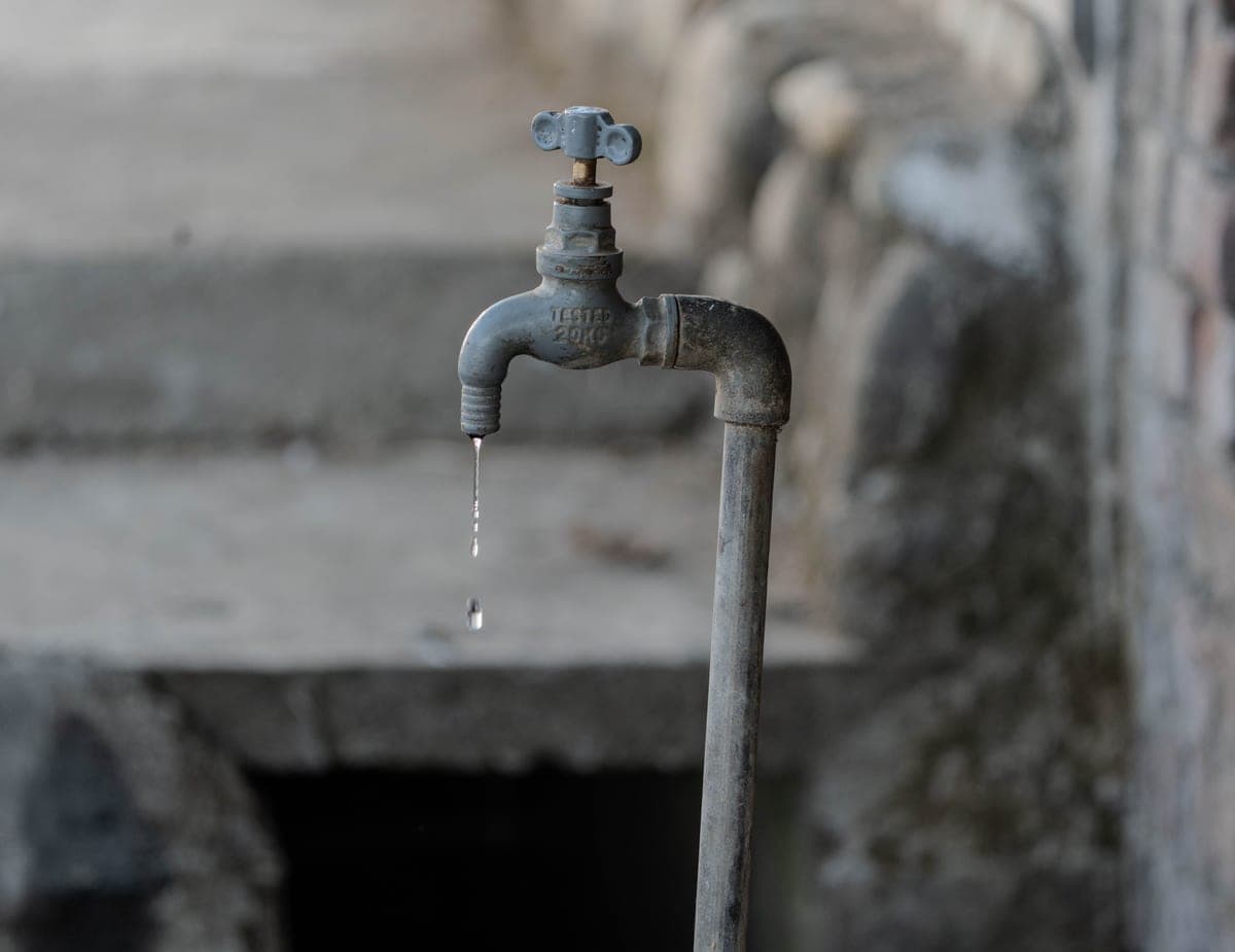 Water droplet falling from a kitchen faucet spout