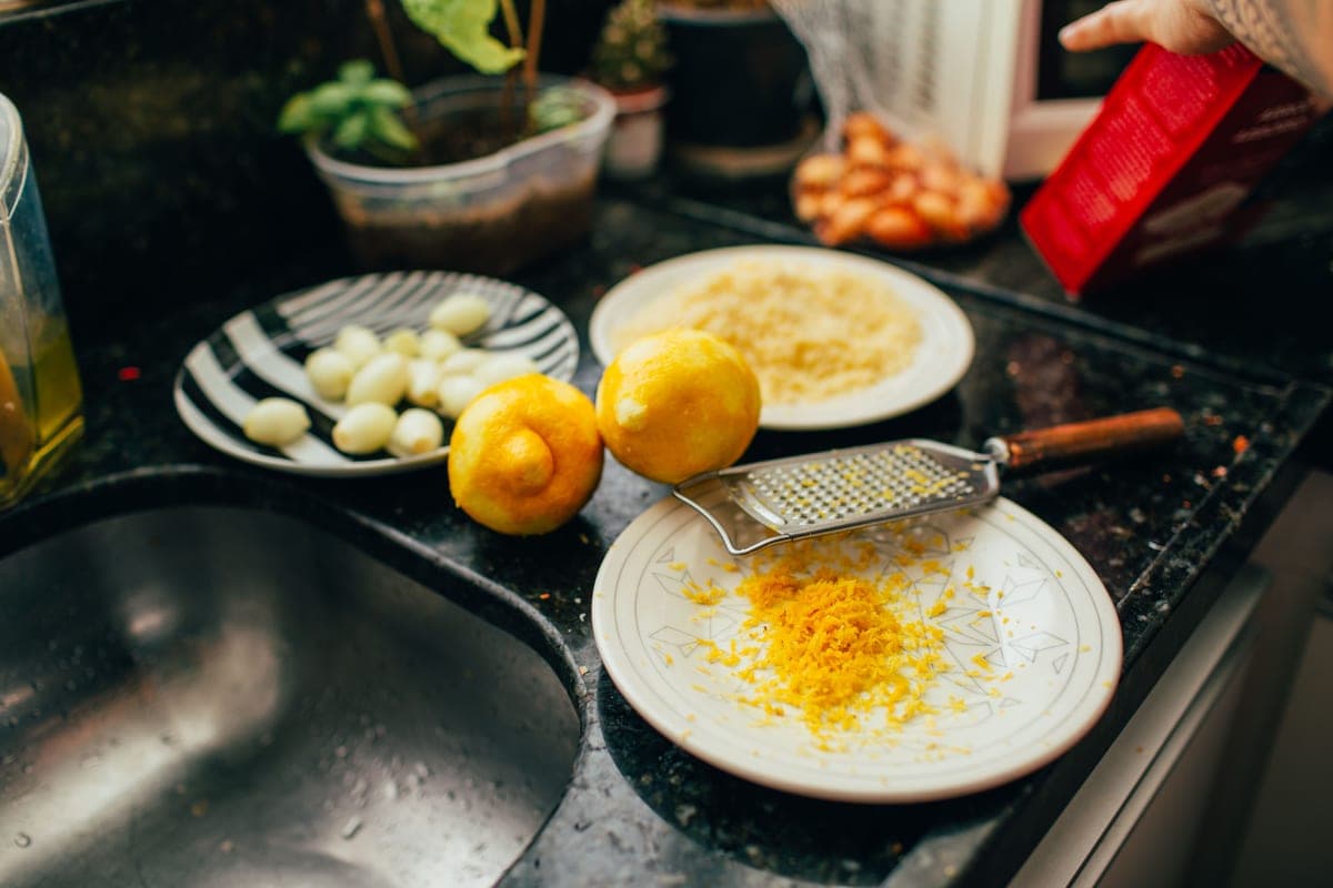Lemon halves and baking soda beside a kitchen sink