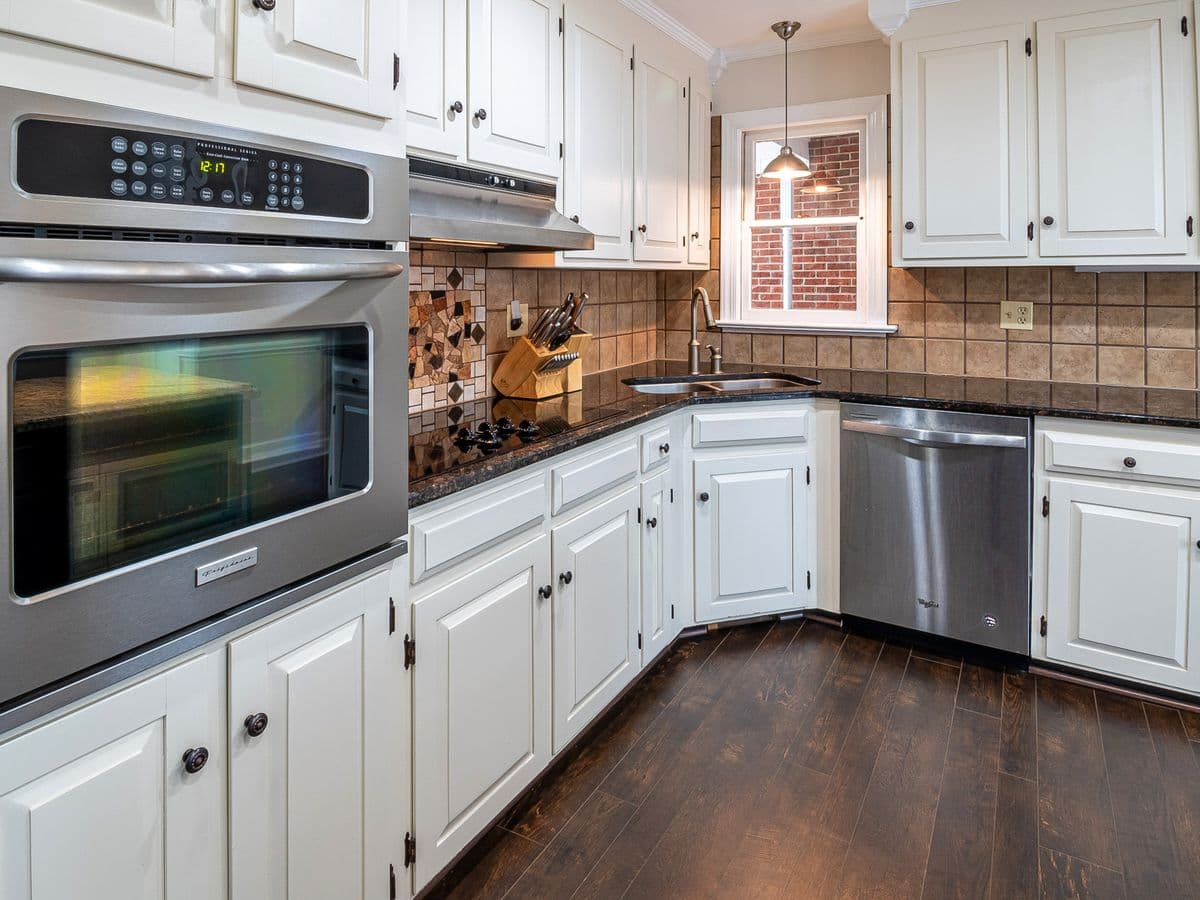Kitchen with white cabinets and a stainless sink set into the countertop
