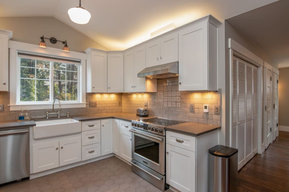 White apron-front farmhouse sink set into wooden cabinetry
