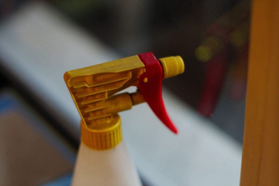 Cleaning products and a sponge beside a kitchen sink