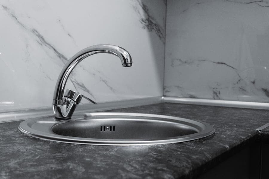 Gooseneck pull-down kitchen faucet in polished chrome on a light countertop