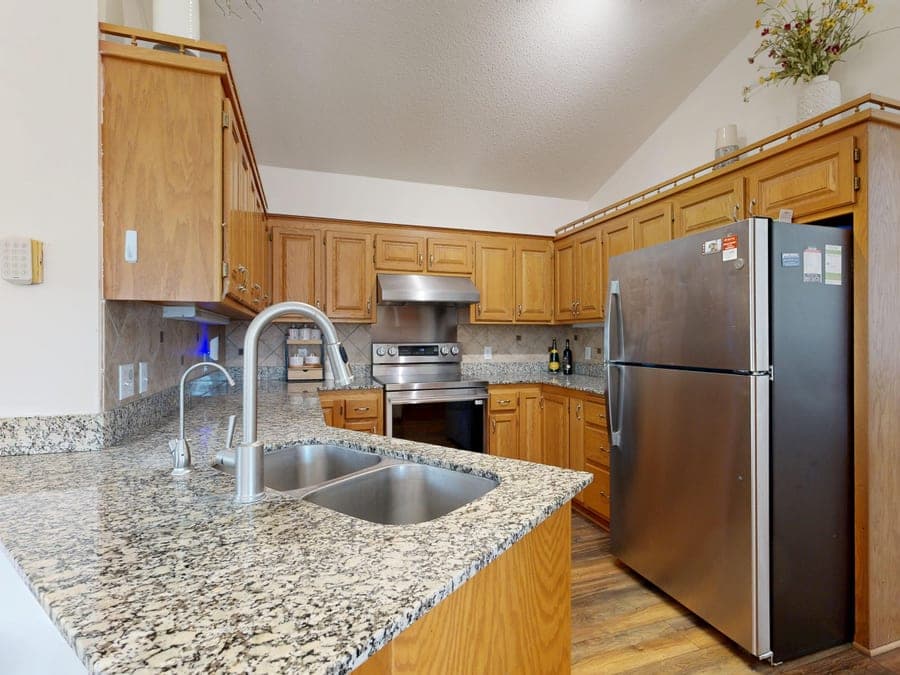 Stainless steel double-bowl kitchen sink in a granite countertop