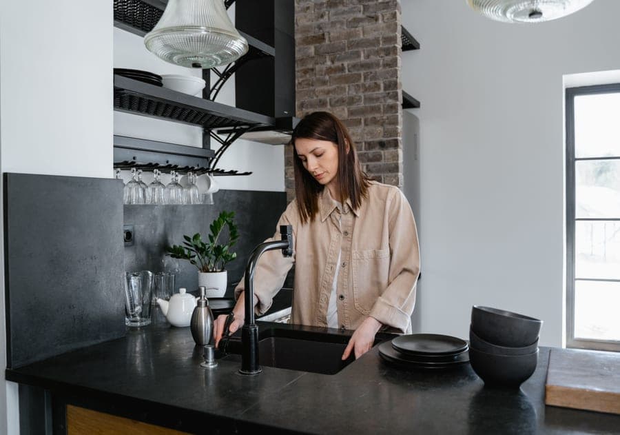 Dark granite composite kitchen sink in a light stone countertop